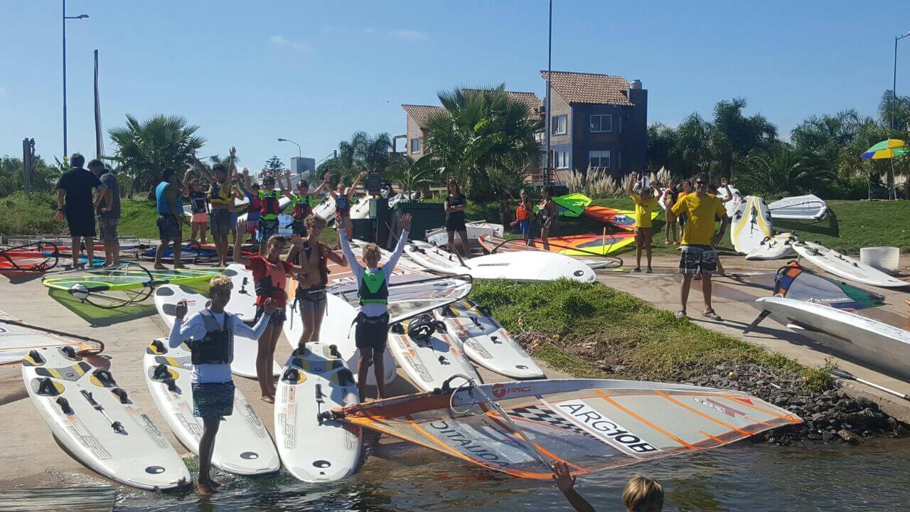 Los chicos preparan sus tablas y velas de Windsurf para salir a navegar